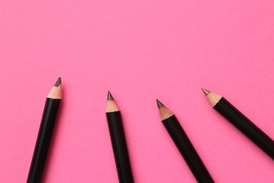 Photo of Different eyebrow pencils on bright pink background, flat lay. Space for text