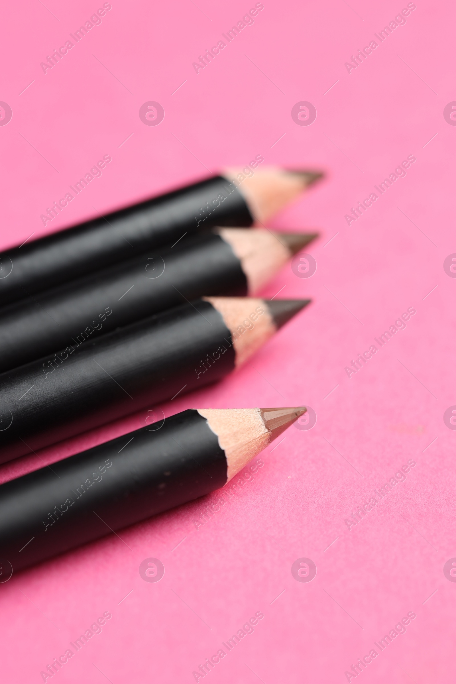 Different eyebrow pencils on bright pink background, closeup Photo of Different eyebrow pencils on bright pink background, closeup