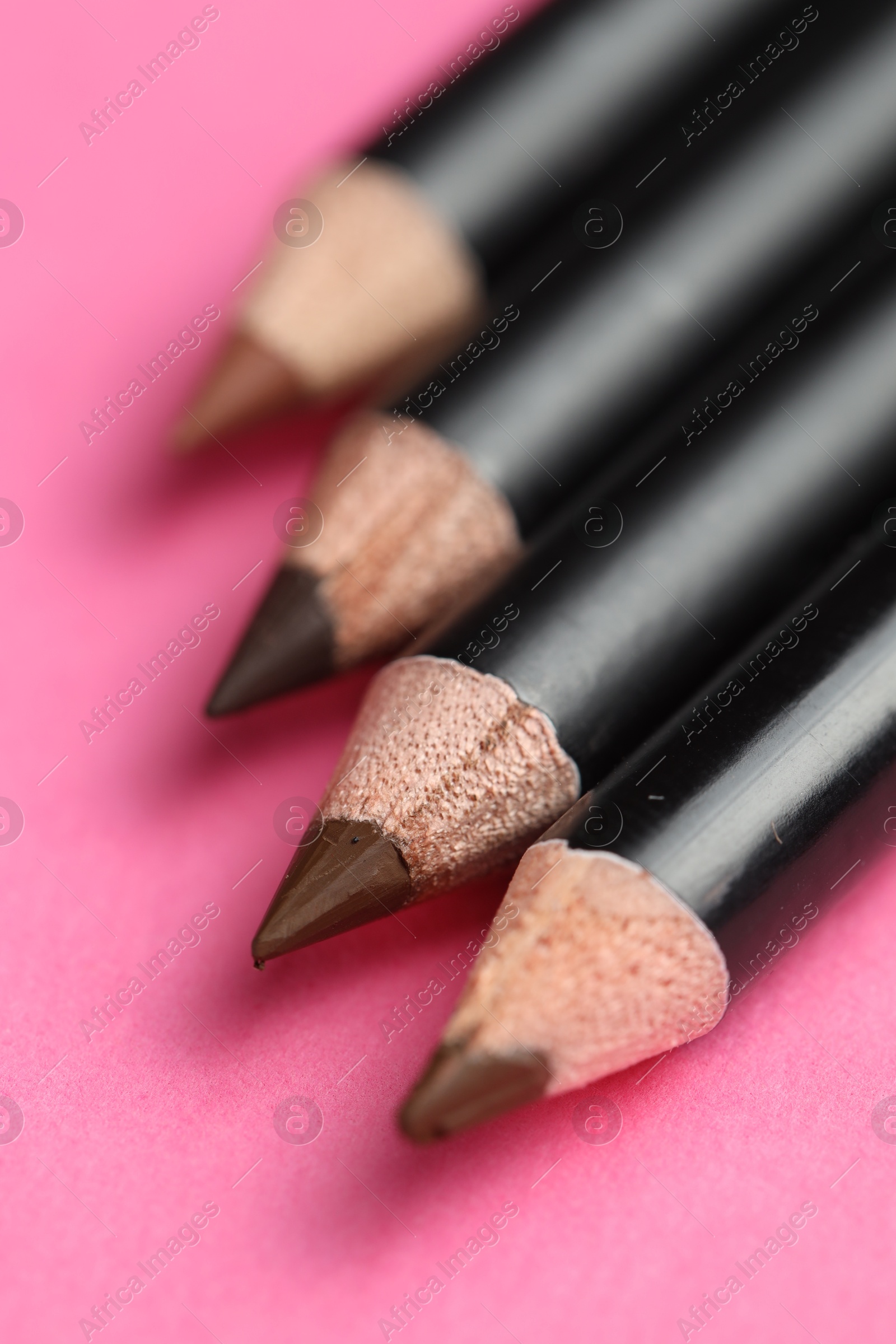 Different eyebrow pencils on bright pink background, closeup Photo of Different eyebrow pencils on bright pink background, closeup