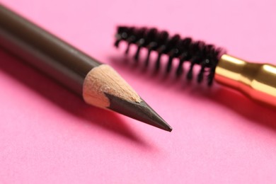 Photo of Different eyebrow pencils on bright pink background, closeup