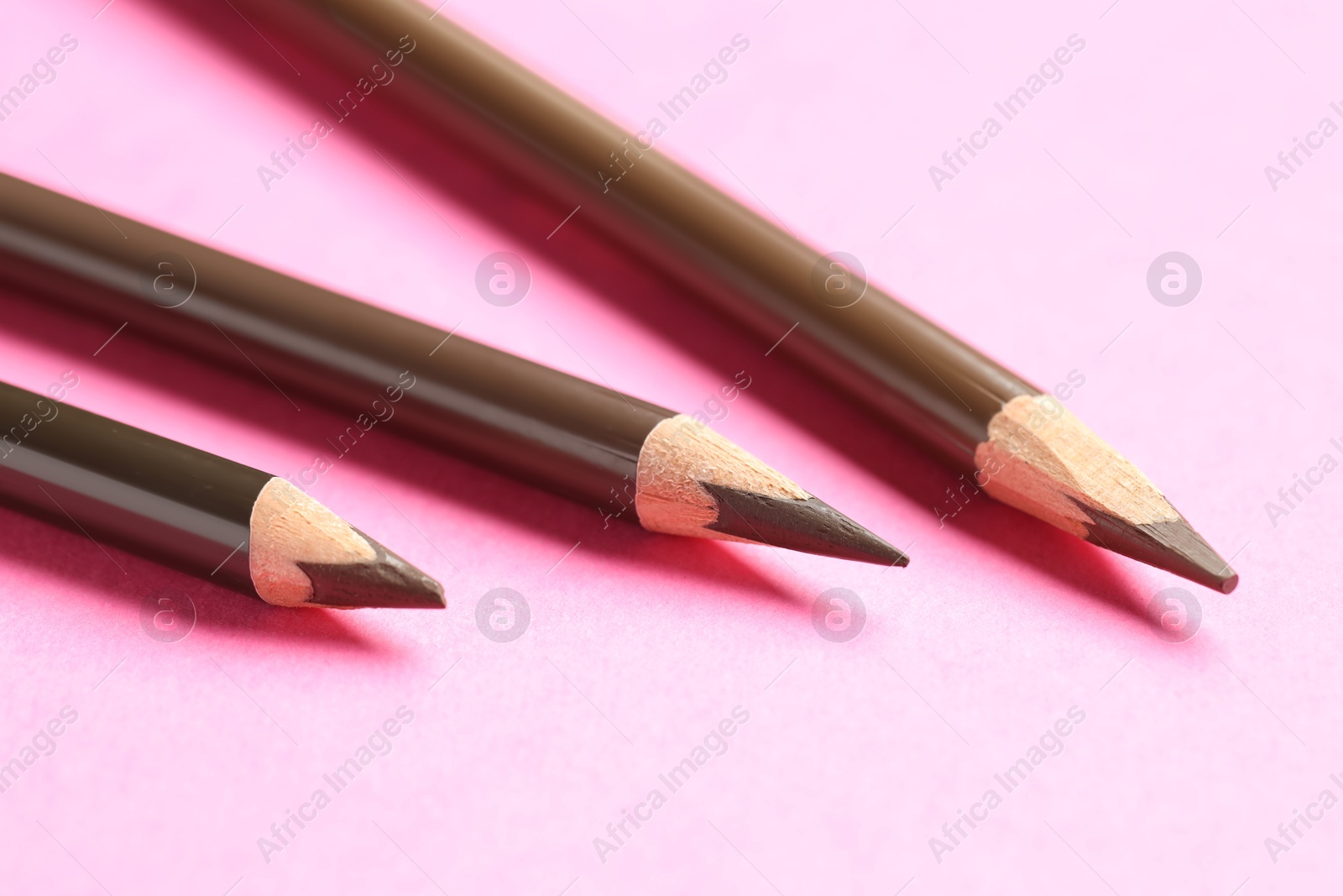 Different eyebrow pencils on bright pink background, closeup Photo of Different eyebrow pencils on bright pink background, closeup