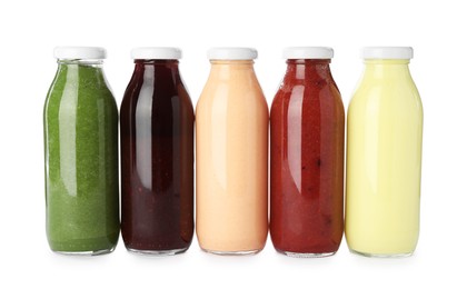 Photo of Superfood. Different tasty smoothies in glass bottles isolated on white