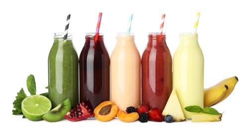 Photo of Superfood. Tasty smoothies in glass bottles and ingredients isolated on white
