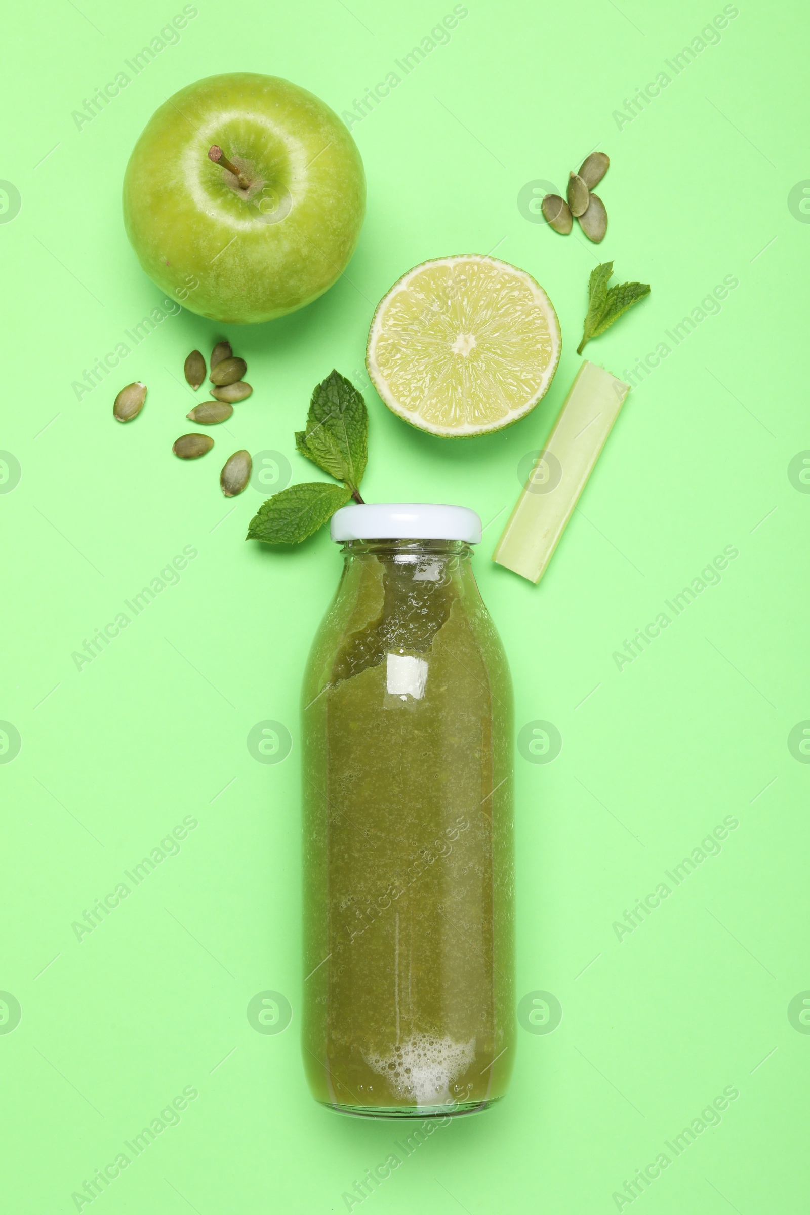 Superfood. Tasty smoothie in glass bottle and ingredients on green background, flat lay Photo of Superfood. Tasty smoothie in glass bottle and ingredients on green background, flat lay