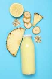 Photo of Superfood. Tasty smoothie in glass bottle and ingredients on light blue background, flat lay