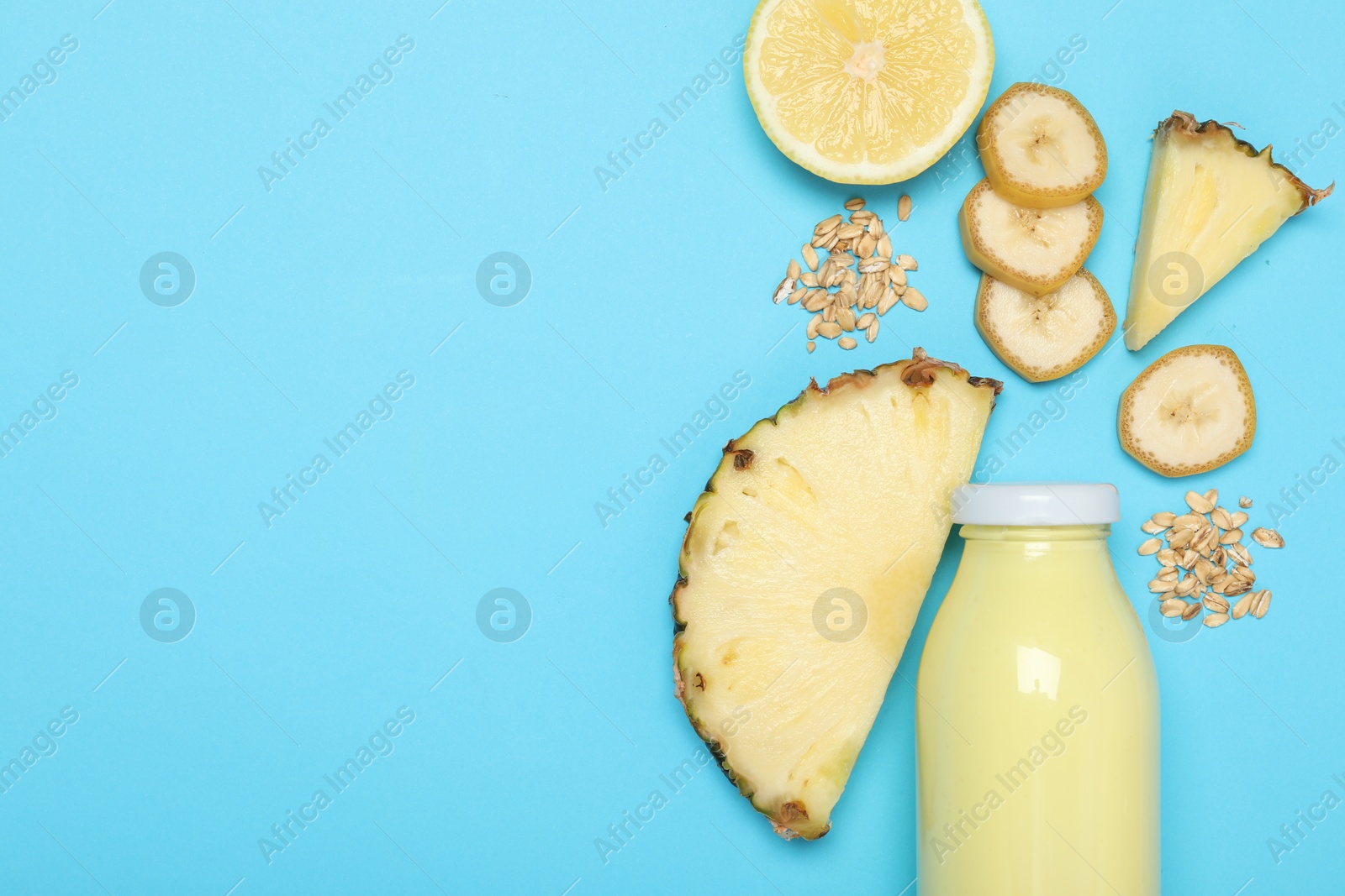Superfood. Tasty smoothie in glass bottle and ingredients on light blue background, flat lay. Space for text Photo of Superfood. Tasty smoothie in glass bottle and ingredients on light blue background, flat lay. Space for text