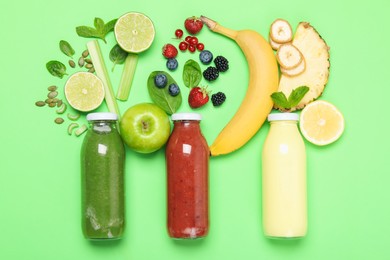 Photo of Superfood. Tasty smoothies in glass bottles and ingredients on green background, flat lay