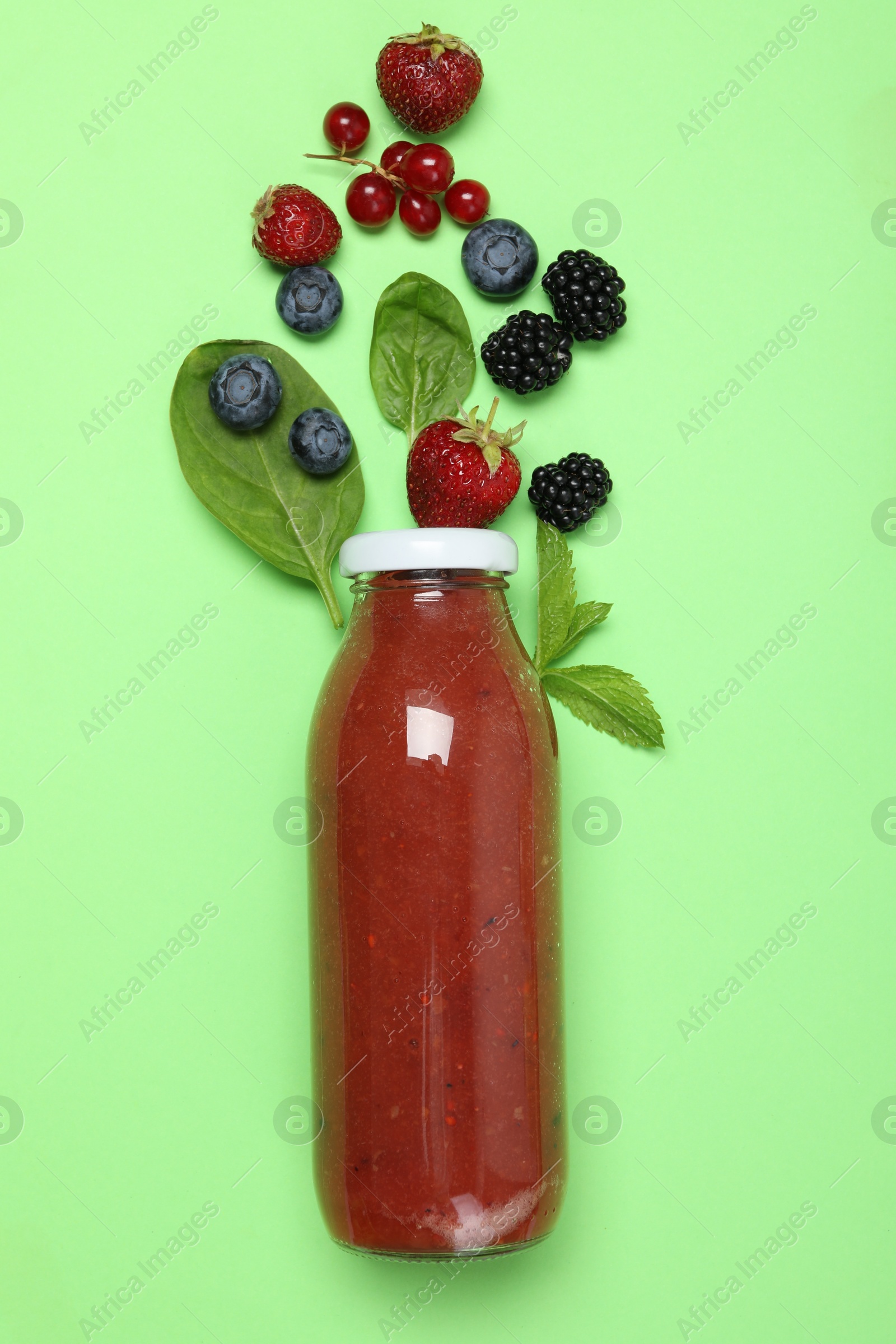 Superfood. Tasty smoothie in glass bottle and ingredients on green background, flat lay Photo of Superfood. Tasty smoothie in glass bottle and ingredients on green background, flat lay