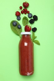 Photo of Superfood. Tasty smoothie in glass bottle and ingredients on green background, flat lay