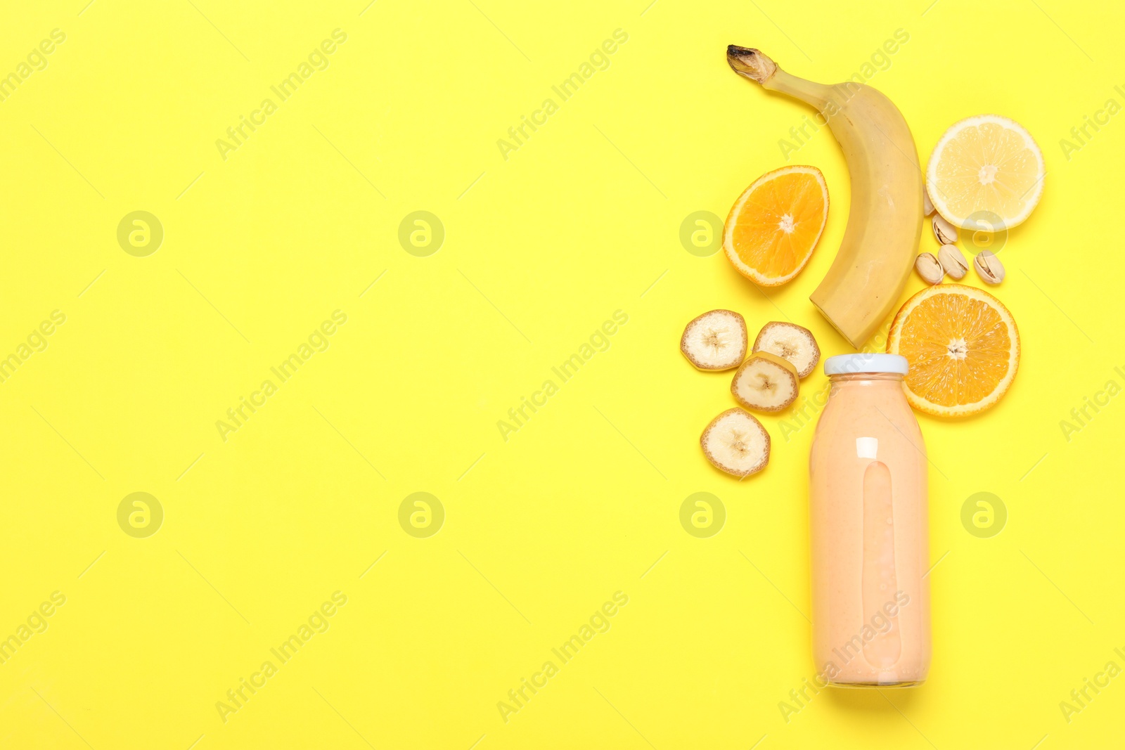 Superfood. Tasty smoothie in glass bottle and ingredients on yellow background, flat lay. Space for text Photo of Superfood. Tasty smoothie in glass bottle and ingredients on yellow background, flat lay. Space for text