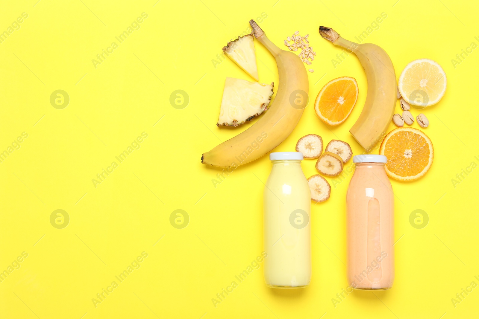 Superfood. Tasty smoothies in glass bottles and ingredients on yellow background, flat lay. Space for text Photo of Superfood. Tasty smoothies in glass bottles and ingredients on yellow background, flat lay. Space for text