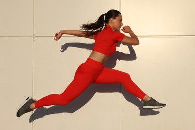 Photo of Woman in sportswear running near building outdoors