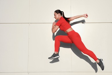 Photo of Woman in sportswear running near building outdoors, space for text