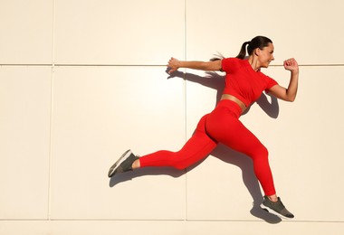 Photo of Woman in sportswear running near building outdoors, space for text