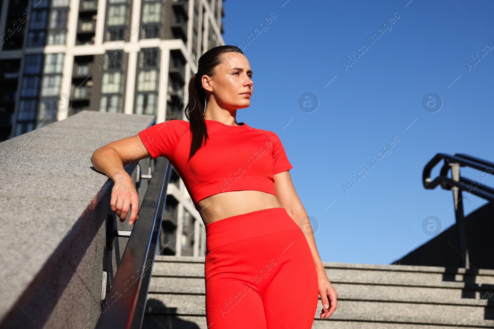 Beautiful woman in sportswear before running on stairs outdoors, low angle view Photo of Beautiful woman in sportswear before running on stairs outdoors, low angle view