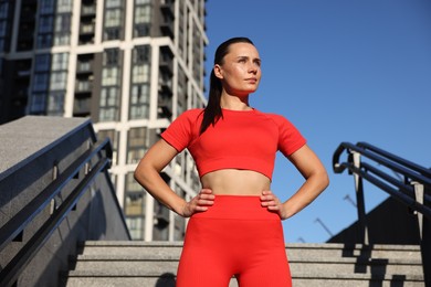 Photo of Beautiful woman in sportswear before running on stairs outdoors, low angle view