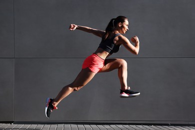 Photo of Woman in sportswear running near building outdoors