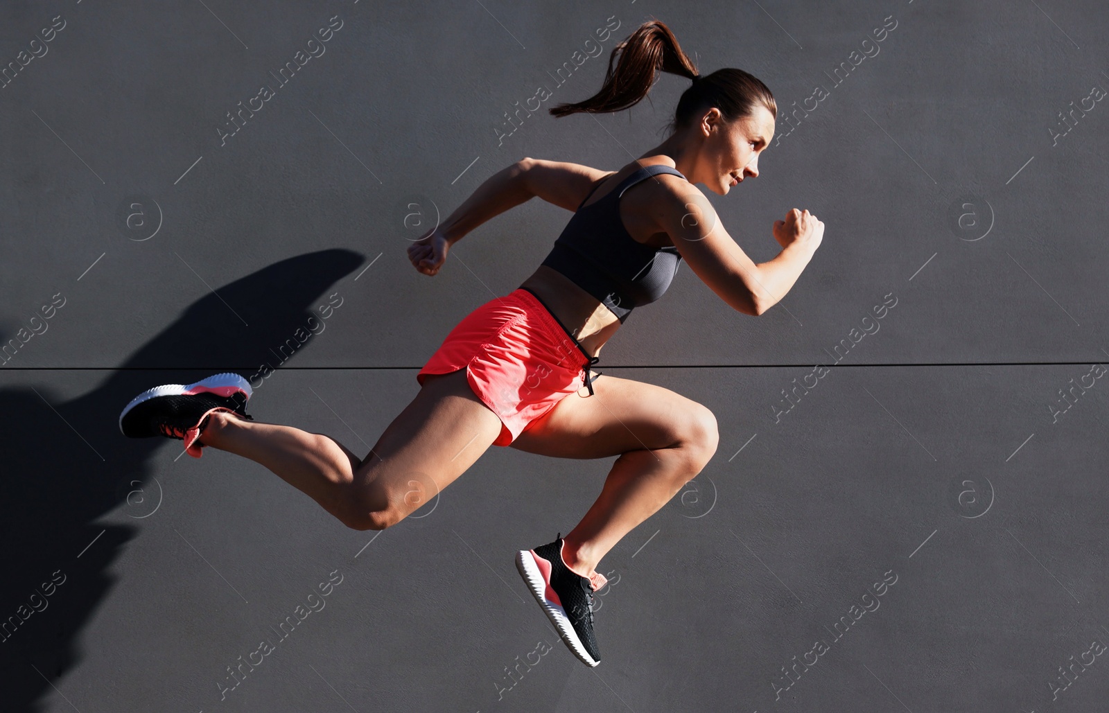 Woman in sportswear running near building outdoors Photo of Woman in sportswear running near building outdoors