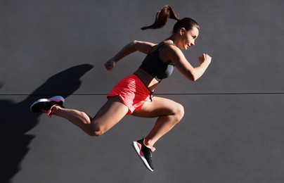 Photo of Woman in sportswear running near building outdoors