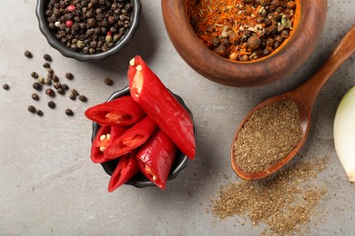 Photo of Different aromatic spices on gray textured table, flat lay