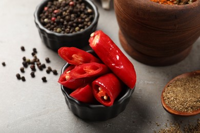 Photo of Different aromatic spices on gray textured table, closeup