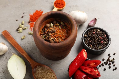 Photo of Different aromatic spices on gray textured table, closeup