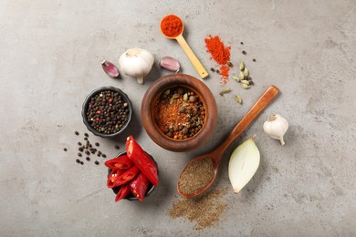 Photo of Different aromatic spices on gray textured table, flat lay