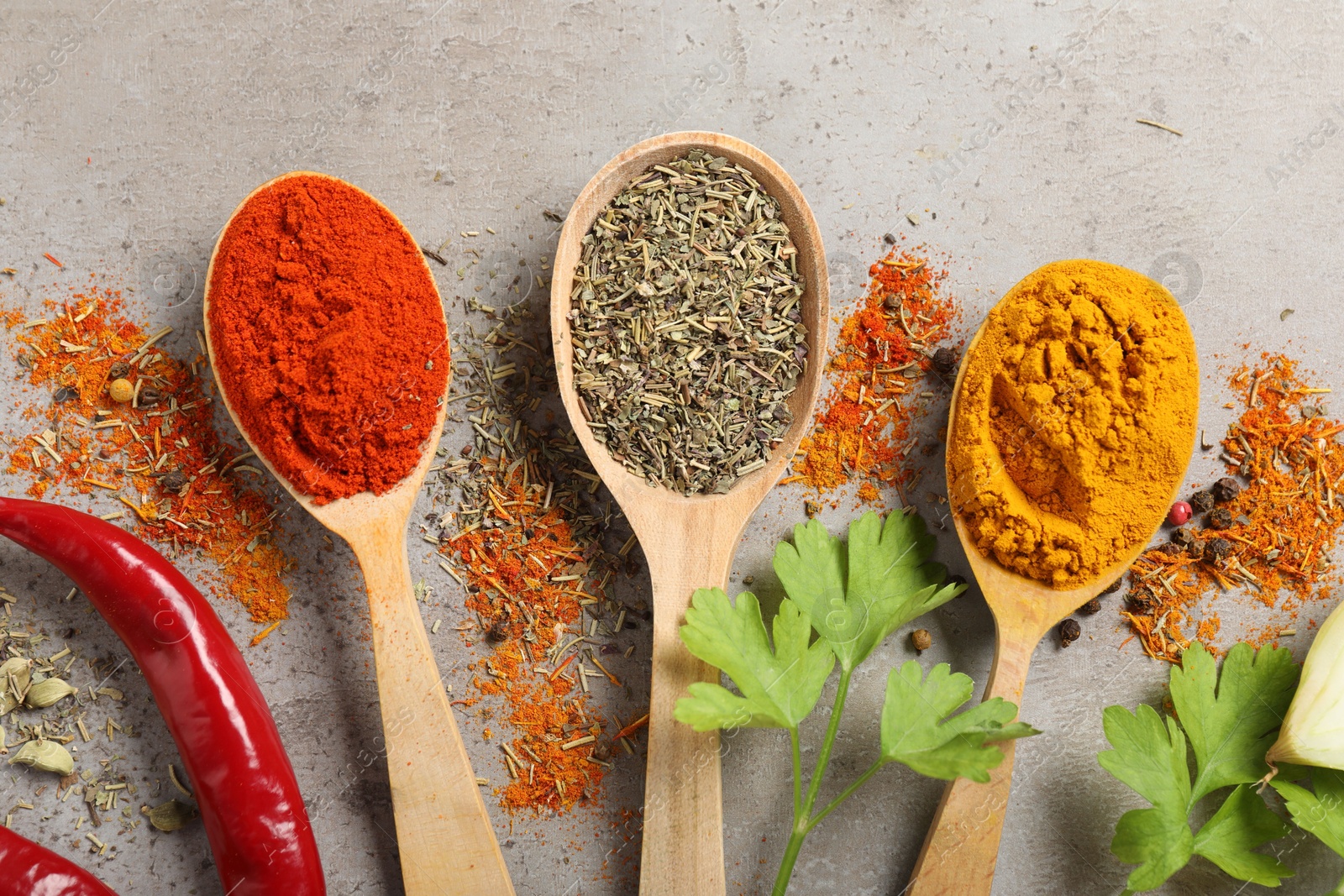 Different aromatic spices on gray textured table, flat lay Photo of Different aromatic spices on gray textured table, flat lay