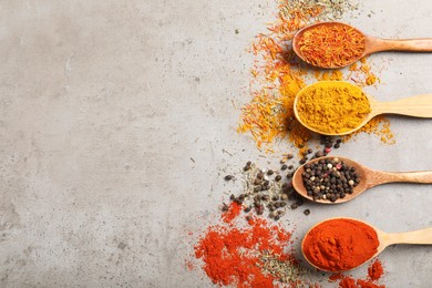 Photo of Different aromatic spices on gray textured table, flat lay. Space for text