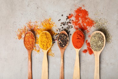 Photo of Different aromatic spices on gray textured table, flat lay