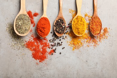 Photo of Different aromatic spices on gray textured table, flat lay