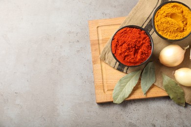 Photo of Different aromatic spices on gray textured table, top view. Space for text