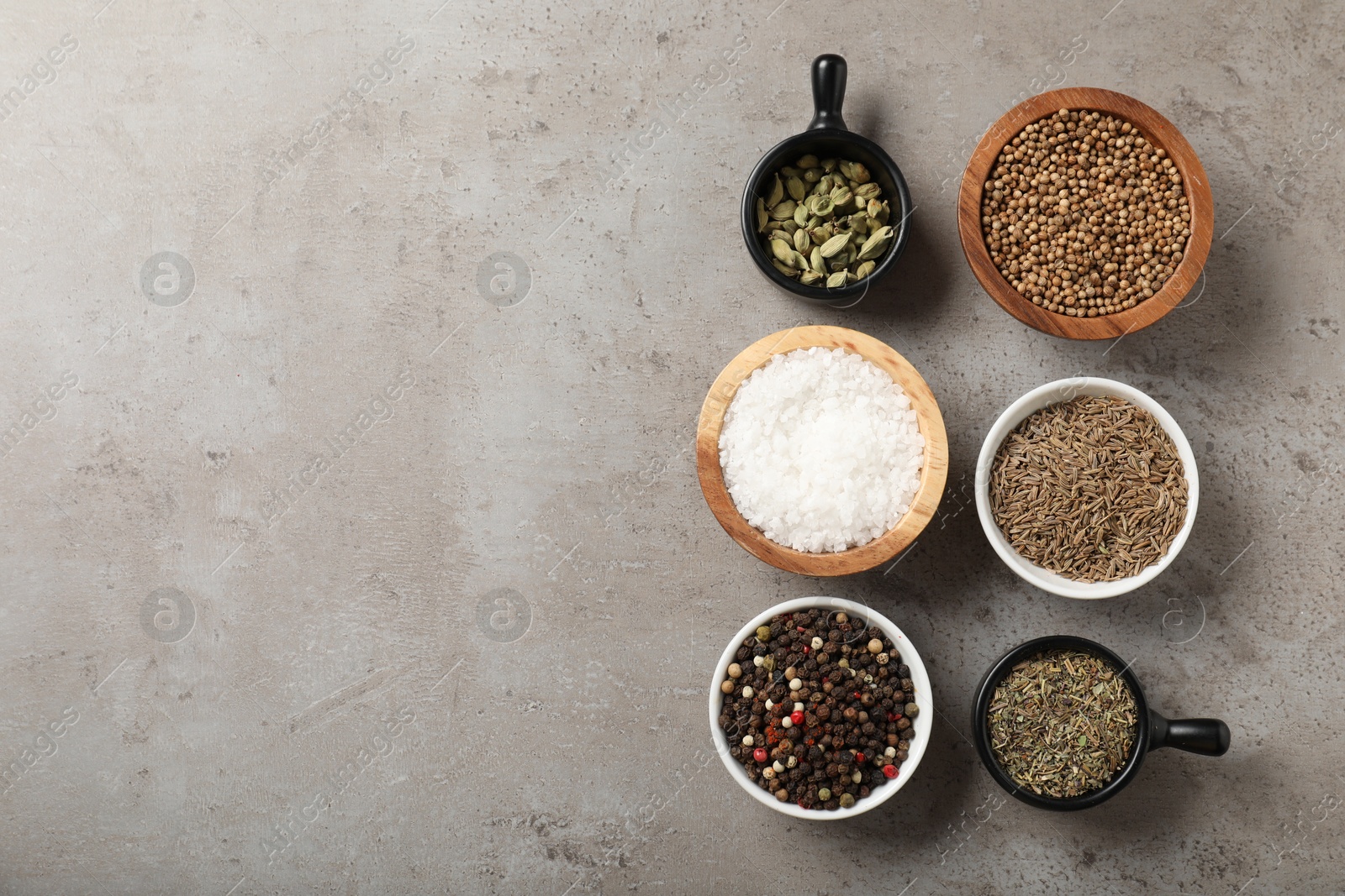 Different aromatic spices on gray textured table, flat lay. Space for text Photo of Different aromatic spices on gray textured table, flat lay. Space for text