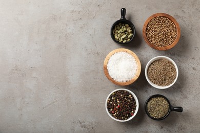Photo of Different aromatic spices on gray textured table, flat lay. Space for text