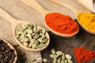 Photo of Different aromatic spices in spoons on table, closeup