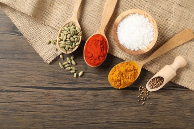 Photo of Different aromatic spices on wooden table, flat lay