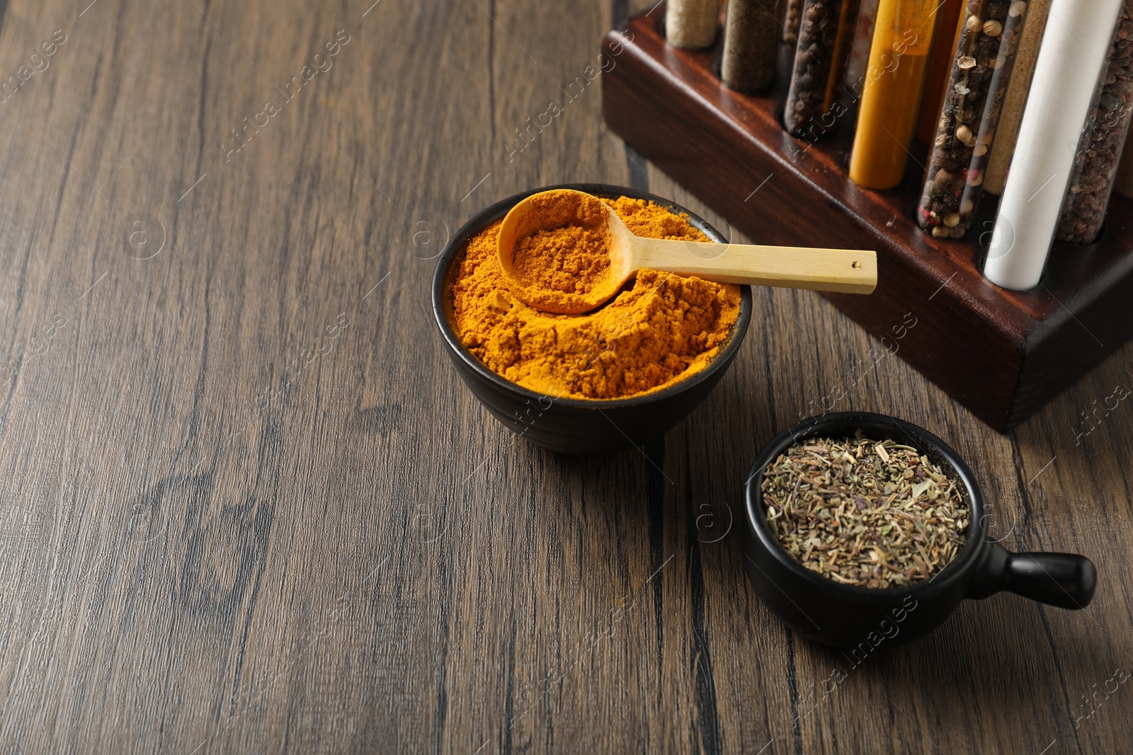 Photo of Different aromatic spices on wooden table, closeup. Space for text
