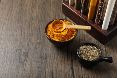 Photo of Different aromatic spices on wooden table, closeup. Space for text