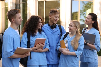 Photo of Group of medical students in uniforms near building outdoors