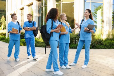 Photo of Group of medical students in uniforms near building outdoors