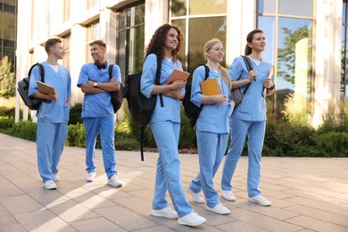 Photo of Group of medical students in uniforms near building outdoors