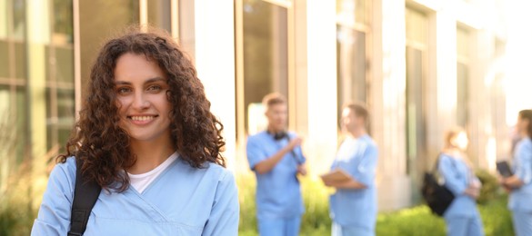 Photo of Happy medical student in uniform outdoors, selective focus