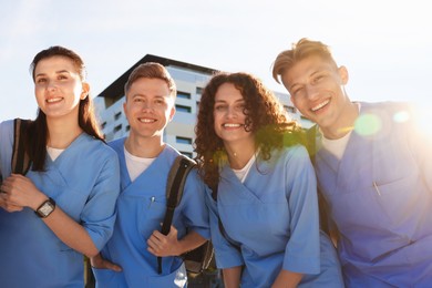 Photo of Group of medical students in uniforms with backpacks outdoors, low angle view