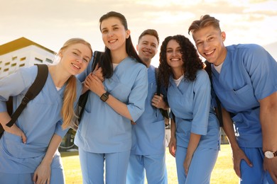 Photo of Group of medical students in uniforms with backpacks outdoors, low angle view