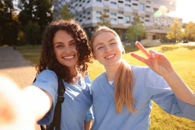 Photo of Medical students taking selfie outdoors on sunny day