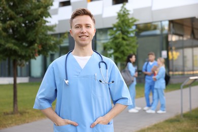 Photo of Medical student in uniform with stethoscope outdoors, selective focus
