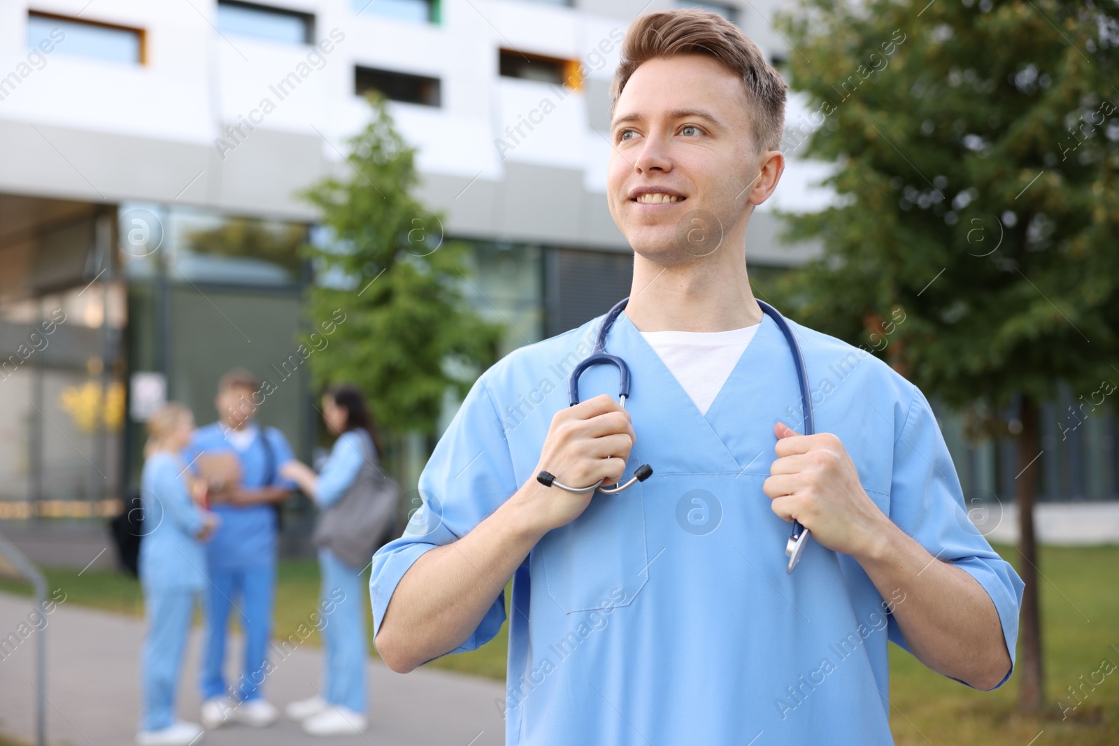 Medical student in uniform with stethoscope outdoors, selective focus Photo of Medical student in uniform with stethoscope outdoors, selective focus