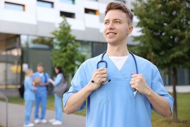 Photo of Medical student in uniform with stethoscope outdoors, selective focus