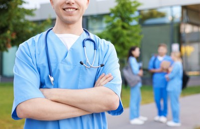 Photo of Medical student in uniform with stethoscope outdoors, selective focus