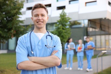Photo of Medical student in uniform with stethoscope outdoors, selective focus